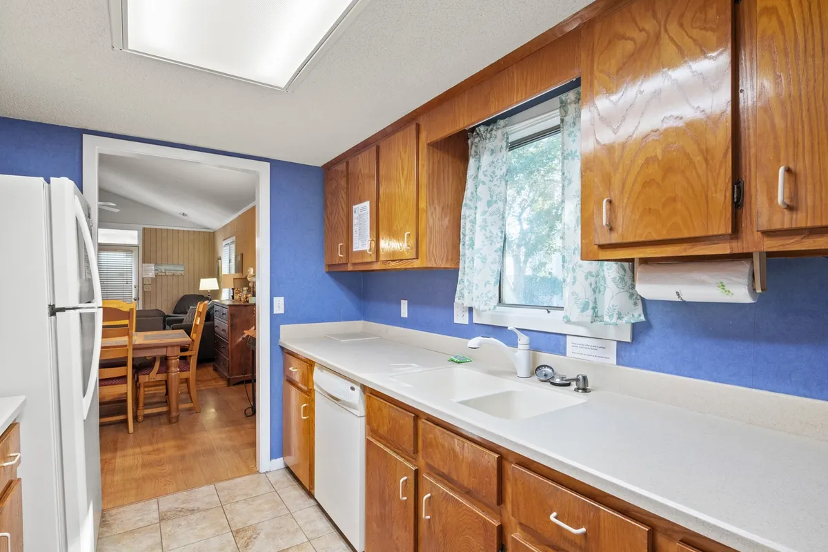 The image showcases a kitchen countertop, wooden cabinets, appliances, and a window with curtains. The atmosphere is warm and homey, evoking images of baking cookies, preparing meals, or hosting dinner parties with friends and family.